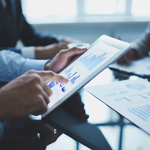 Image of businessperson pointing at document in touchpad at meeting